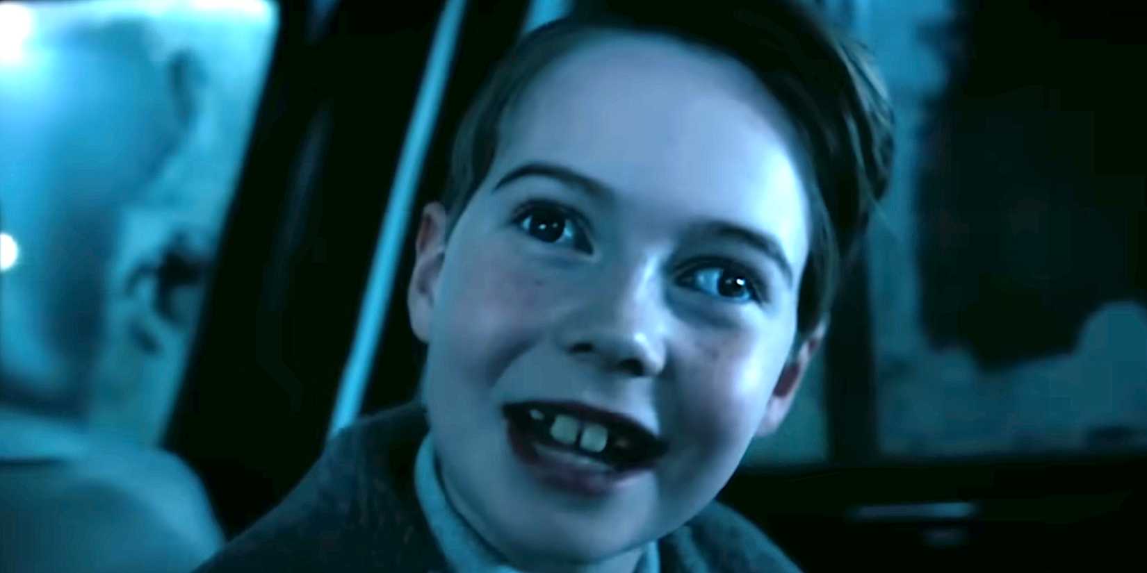 A child smiles with Pennywise's signature unsettling eyes in IT Welcome to Derry trailer