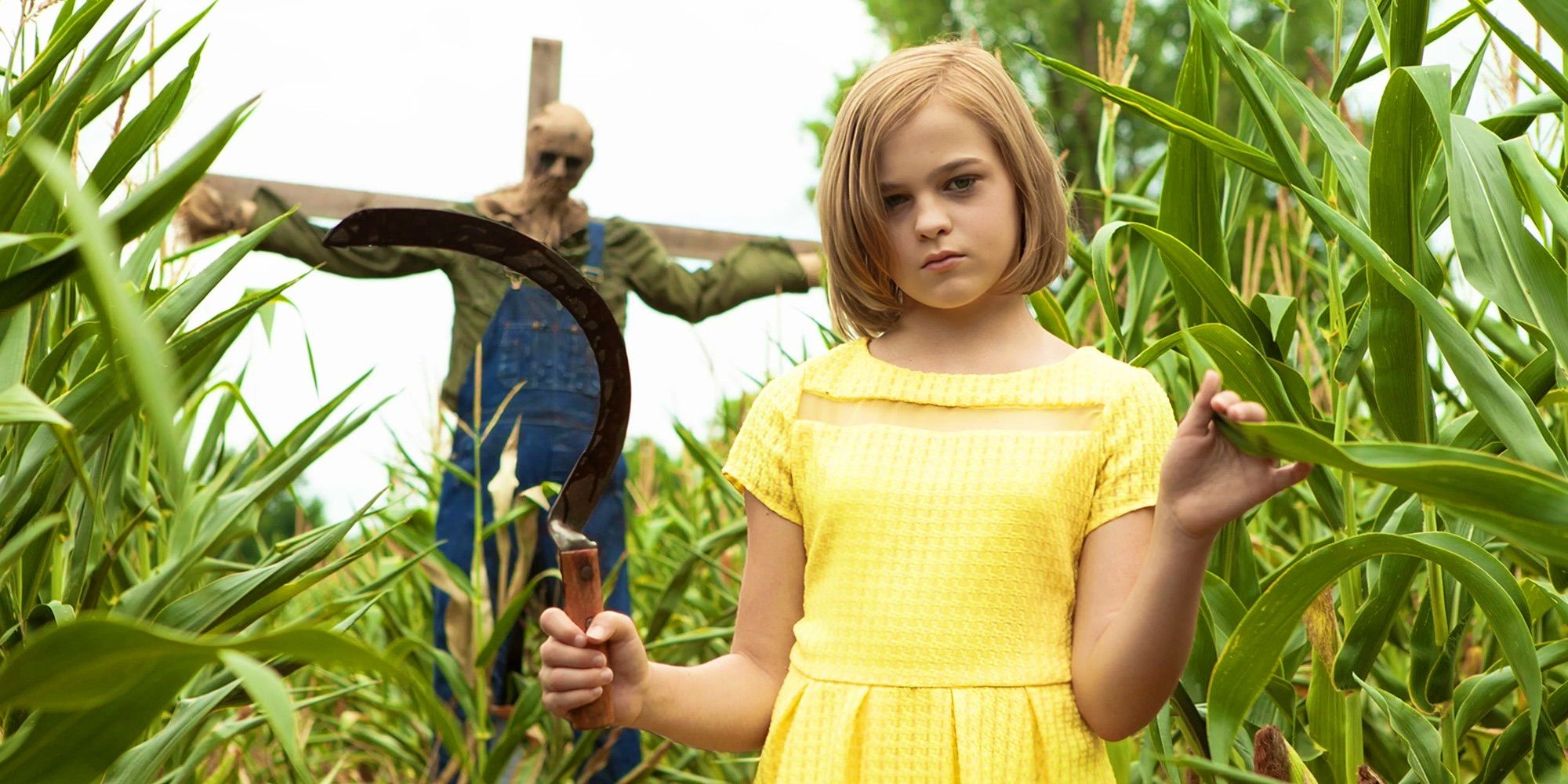 A killer child holding a sickle near a scarecrow in Children of the Corn_ Runaway