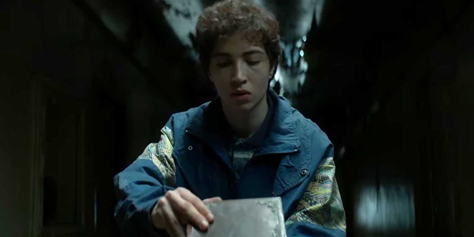 A teenager slowly opening the phonograph in Whisper of the Witch