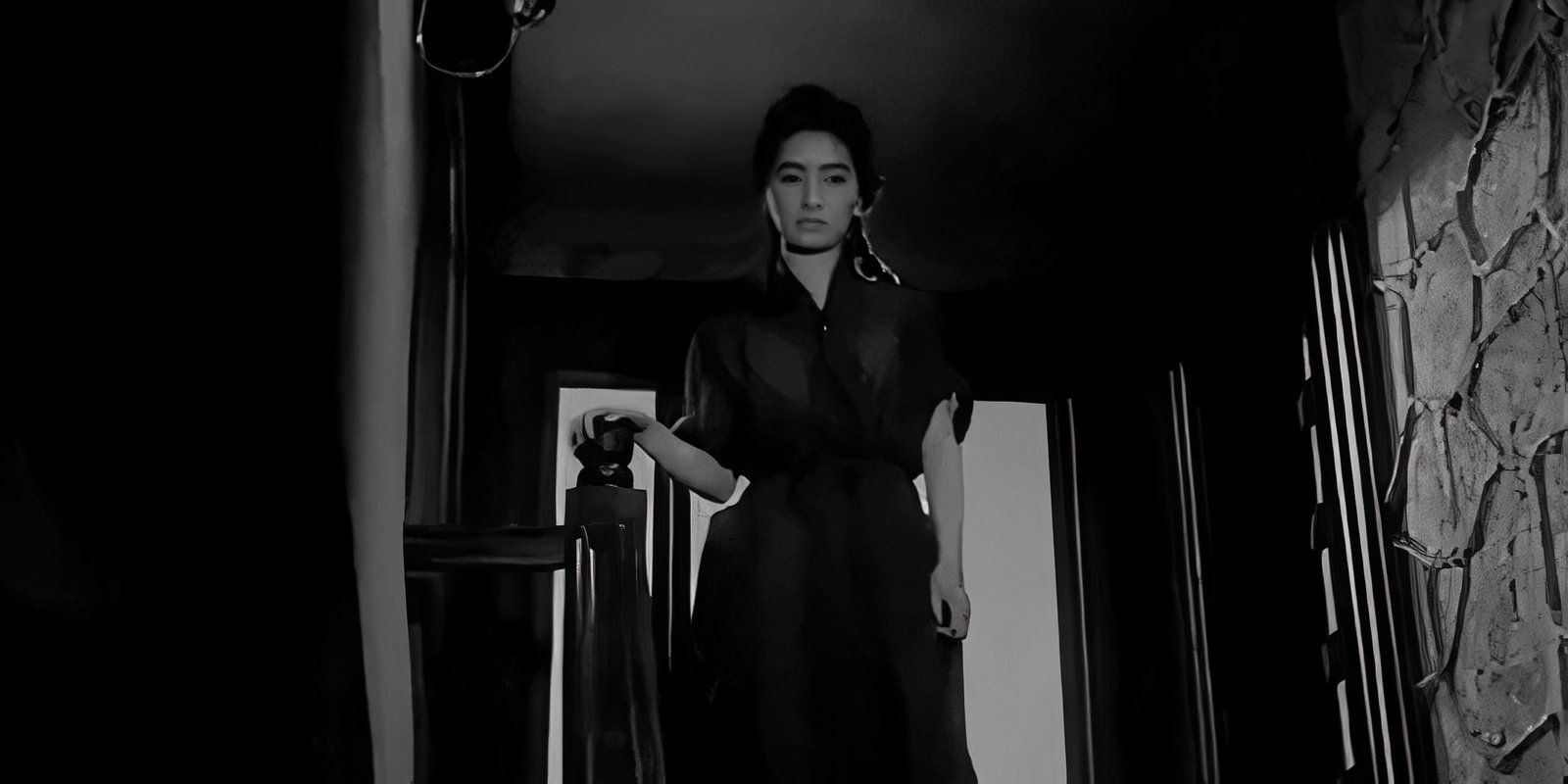 A woman standing at the top of a staircase in The Housemaid