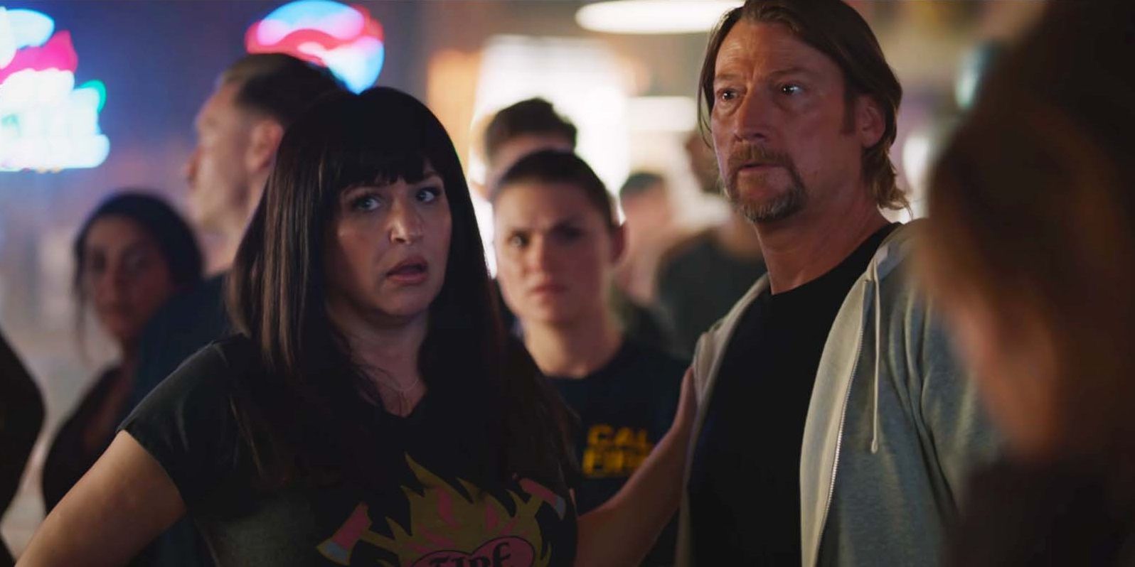 April Telek as Dolly and Aaron Pearl as Paulie looking preoccupied in Fire Country season 1, episode 11