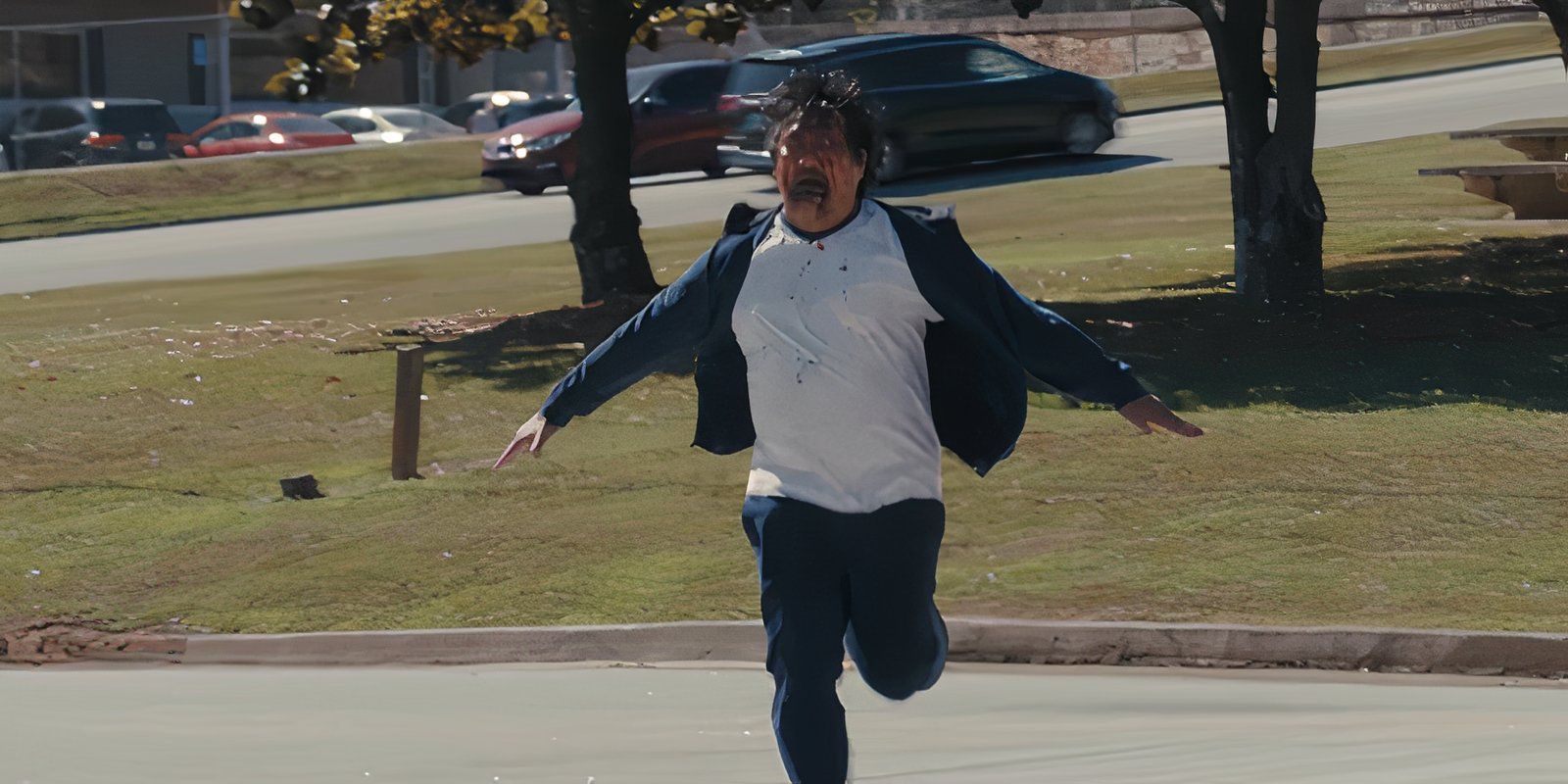 Benedict Wong running with a bloodied face in the horror film Weapons