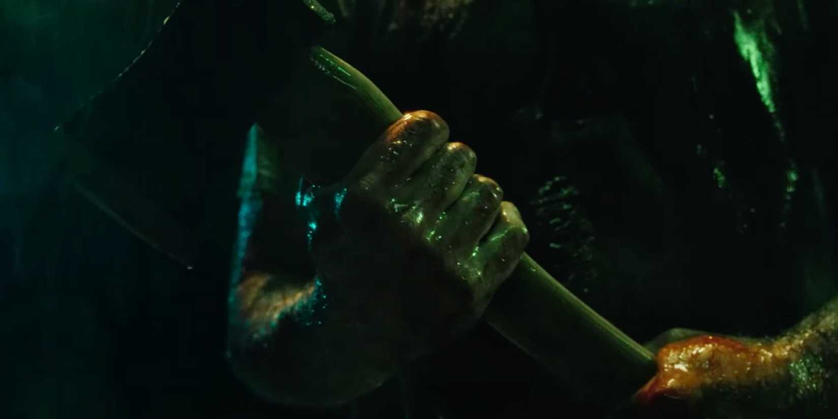 Hands firmly gripping an ax handle in Bone Lake