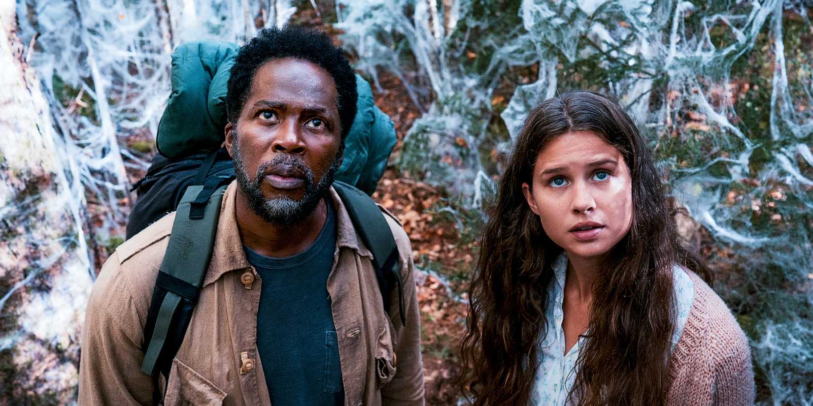 Boyd (Harold Perrineau) and Sara (Avery Konrad) looking up at something with webs behind them in From