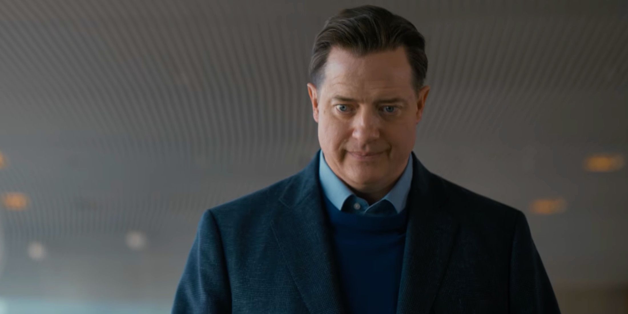 Brendan Fraser in Rental Family wearing a suit and looking downward 