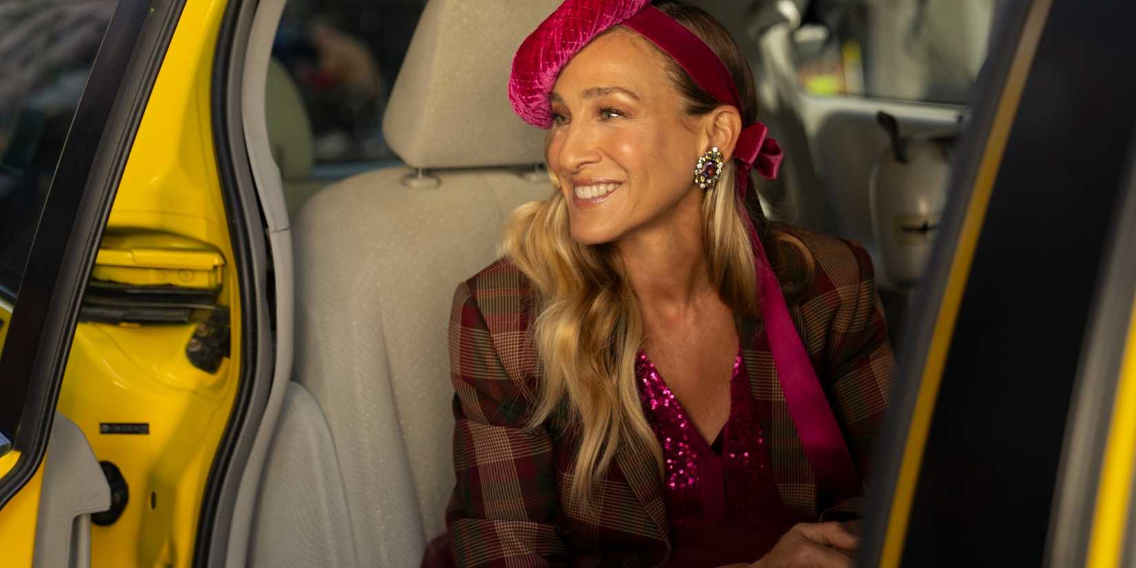 Carrie Bradshaw (Sarah Jessica Parker) smiling in a cab in the And Just Like That season 3 finale