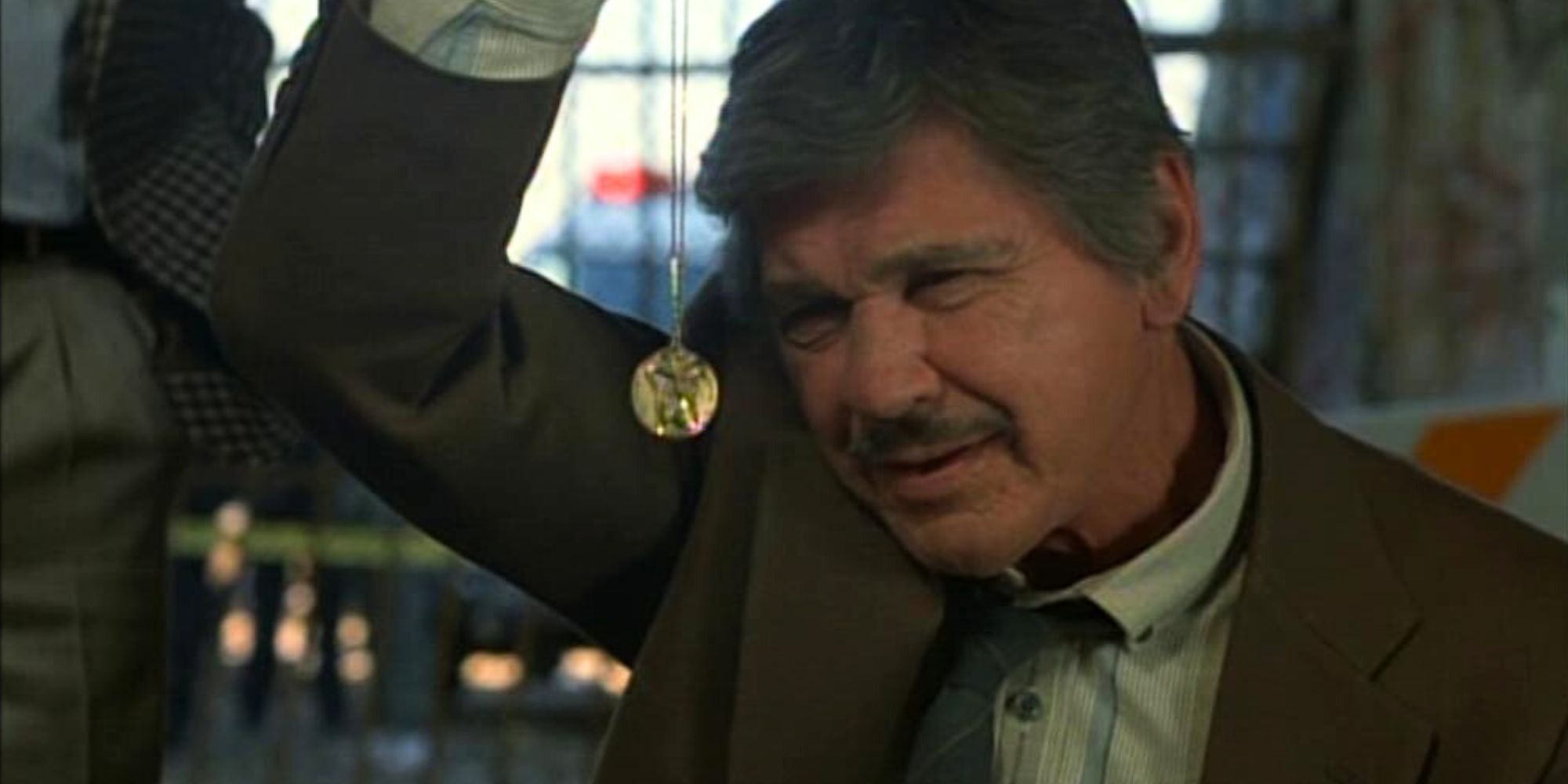 Charles Bronson as Detective Jack Murphy looking at a necklace in Murphy's Law