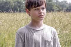 Creepy child stands in a field in Goodnight Mommy.