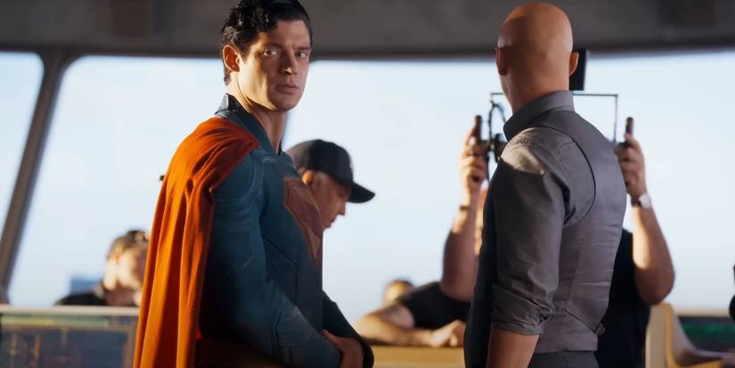 David Corenswet as Superman looking off-screen stood next to Nicholas Hoult as Lex Luthor
