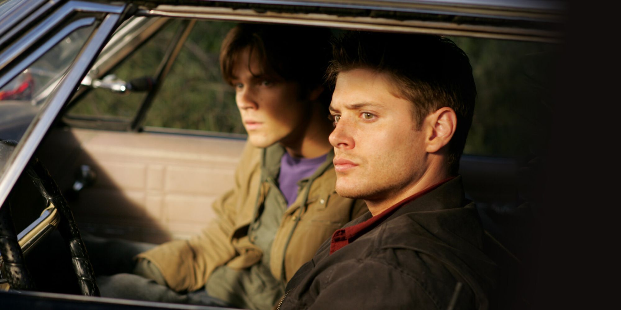 Dean (Jensen Ackles) and Sam Winchester (Jared Padalecki) sitting in their car in Supernatural.