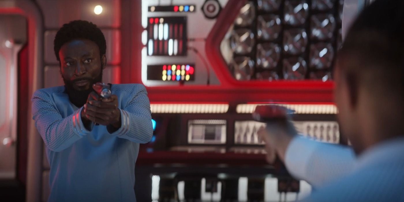 Dr. M'Benga pointing a phaser at Ensign Gamble in Star Trek Strange New Worlds season 3 Through the lens of time