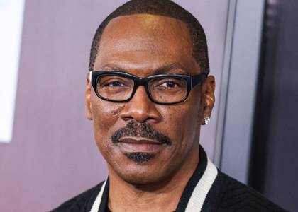 Eddie Murphy looks on with a smirk on the red carpet for You People