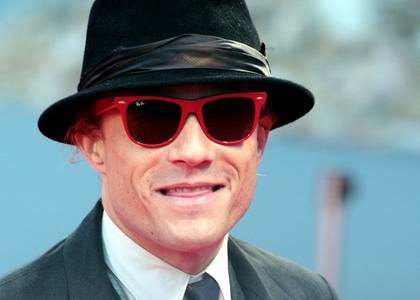 Heath Ledger grins mischievously while walking the red carpet at a film festival