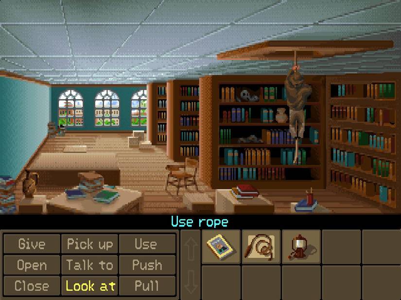 Indiana Jones and the fate of atlantis screenshot of indiana climbing up a rope into the ceiling inside a library