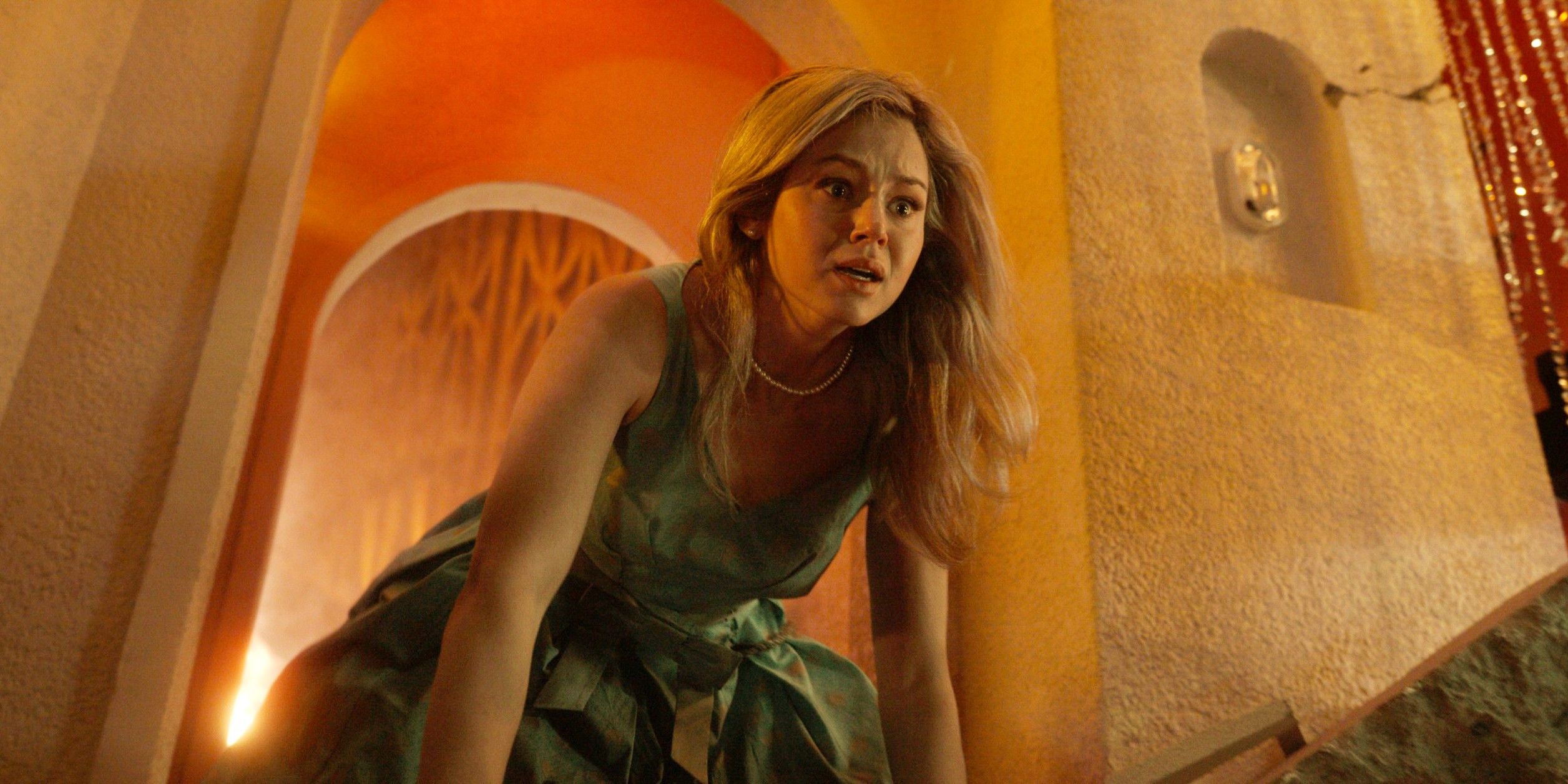 Iris on her hands and knees looking at something in horror at the Skyview restaurant in Final Destination Bloodlines