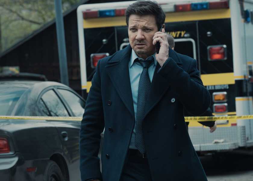 Jeremy Renner on the phone walking away from an ambulance in Mayor of Kingstown
