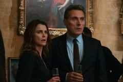 Keri Russell and Rufus Sewell looking shocked while standing close to one another in The Diplomat