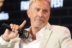 Kevin Costner holding a microphone