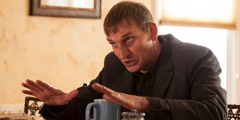 Matt leans across a table in The Leftovers