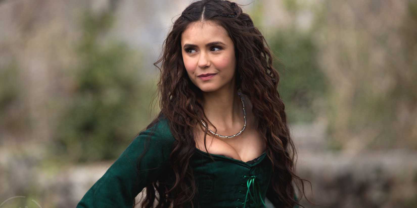 Nina Dobrev as Katherine wearing a green dress and smiling In The Vampire Diaries