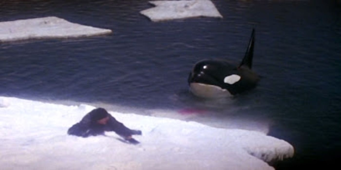 A man slides down an iceberg as a killer whale waits to eat him in Orca