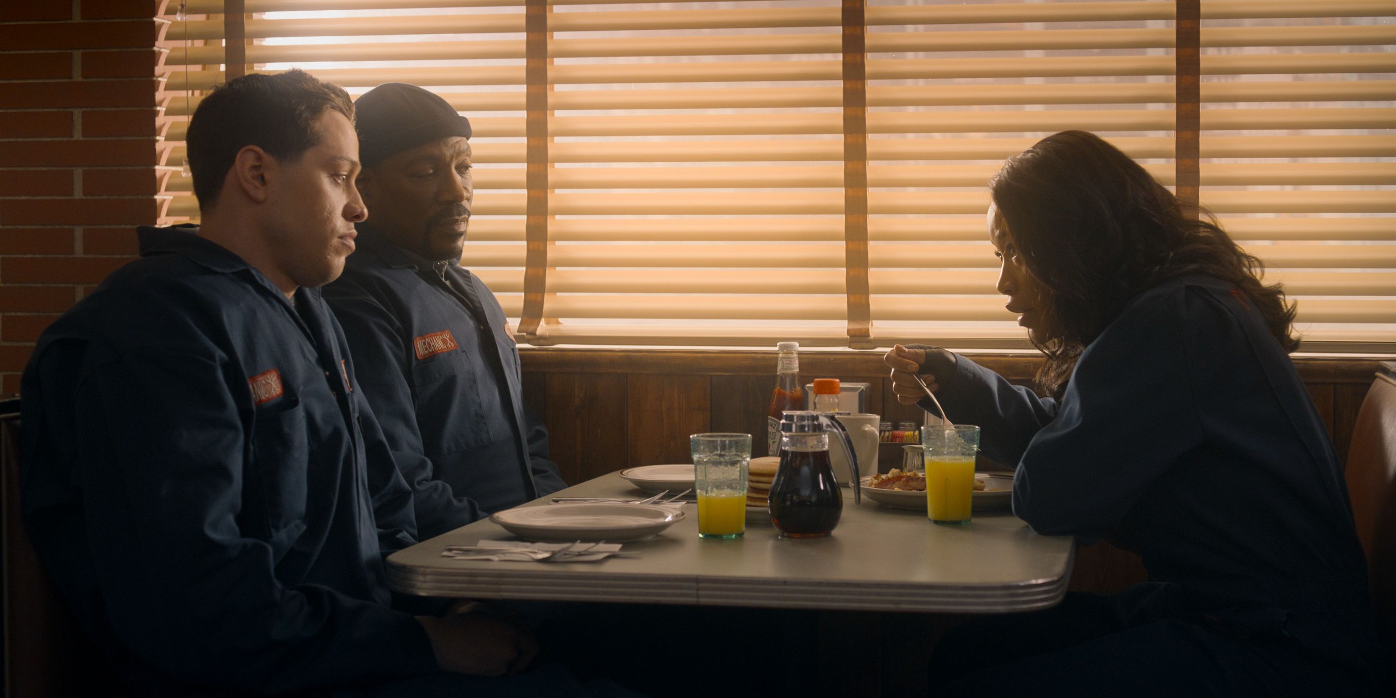 Pete Davidson, Eddie Murphy and Keke Palmer talking furtively over breakfast in The Pickup