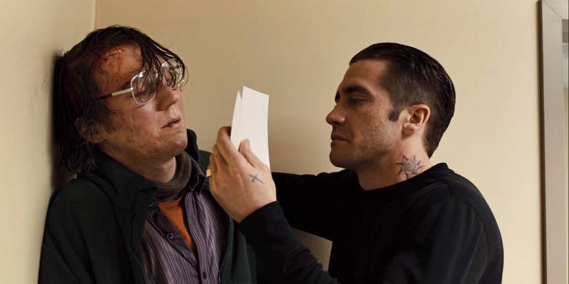 Jake Gylenhaal segurando Paul Dano contra um muro em prisioneiros.