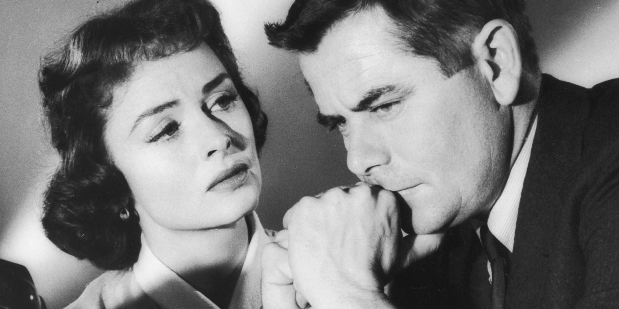 A woman and a man huddled close together in Ransom! 1956