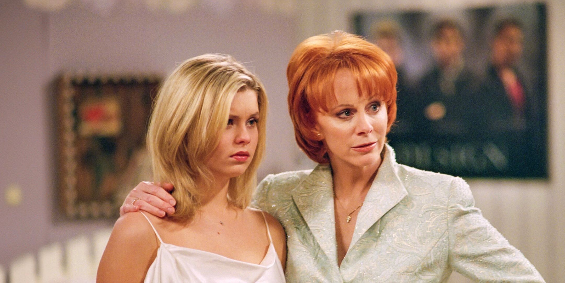 Reba puts a protective arm around a young girl in Reba