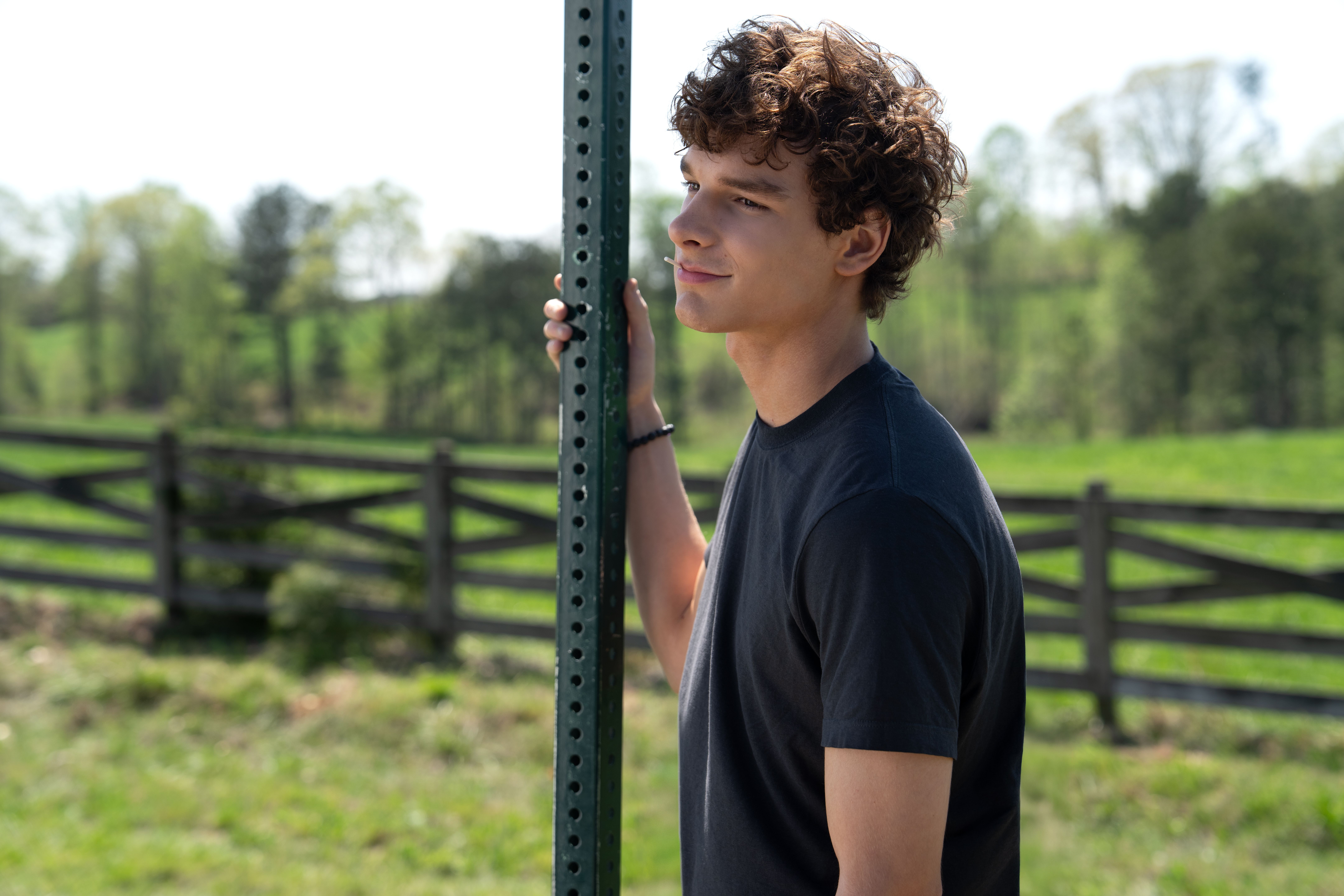 Mason Thames as Miller Adams standing beside a road sign in Regretting You