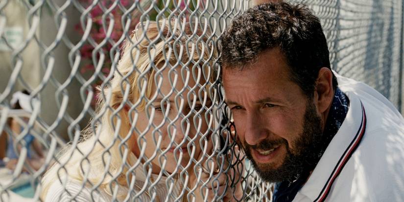 Adam Sandler leaning against a fence in Jay Kelly