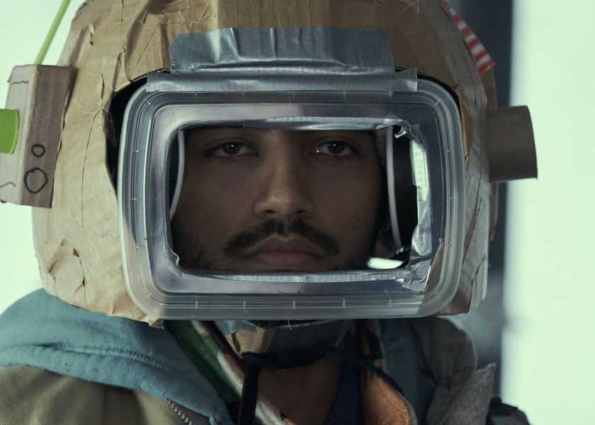 Frank (Nabhaan Rizwan) staring through an isolation suit in STATION ELEVEN âGoodbye My Damaged Home', (Season 1, ep. 107, aired Dec. 30, 2021) (1)
