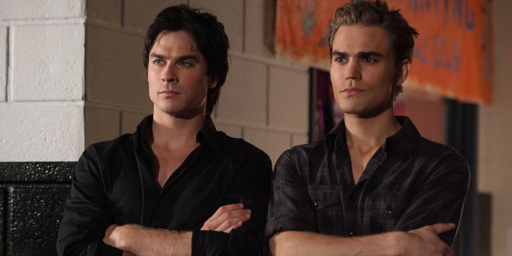 Stefan and Damon stand side by side with their arms crossed in The Vampire Diaries (1)