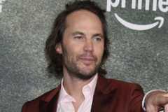 Taylor Kitsch pointing at someone while at the red carpet of Terminal List