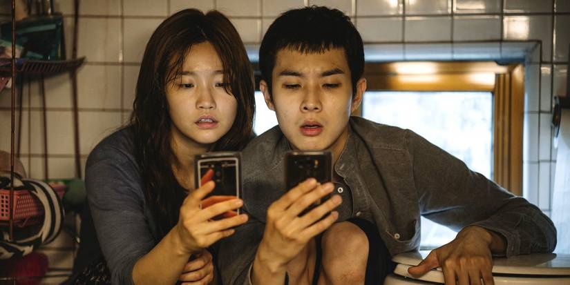 The brother and sister looking at their phones in Parasite