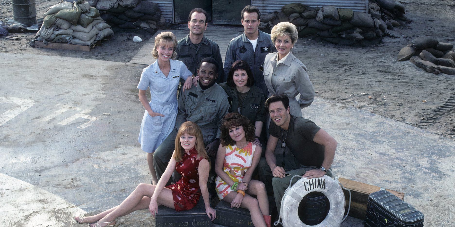 The cast of China Beach posed together on a set