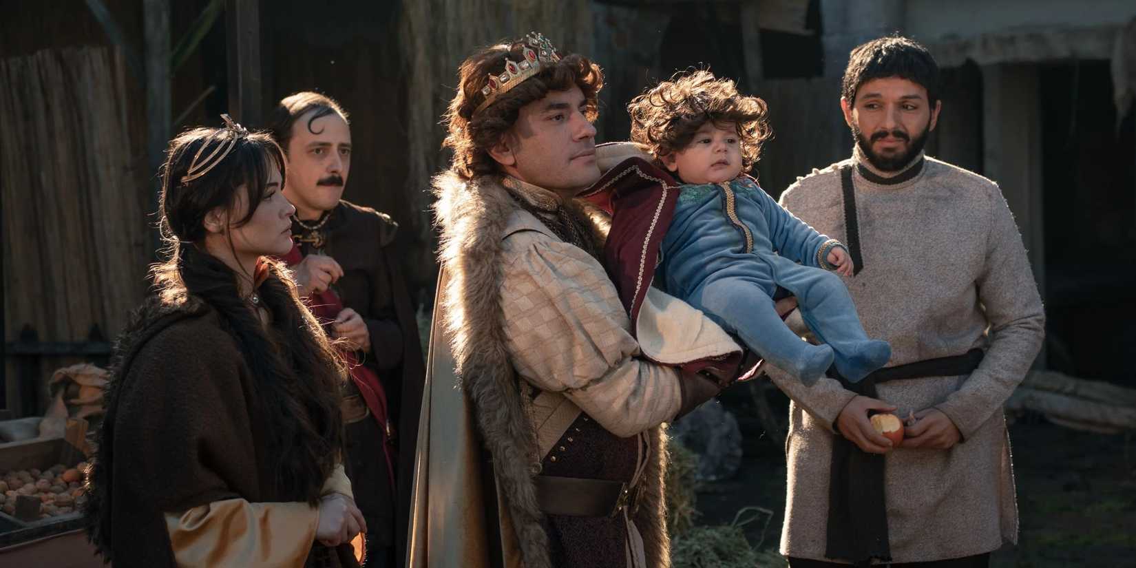 The Prince (Giray Altinok) holding up a baby in The Prince.