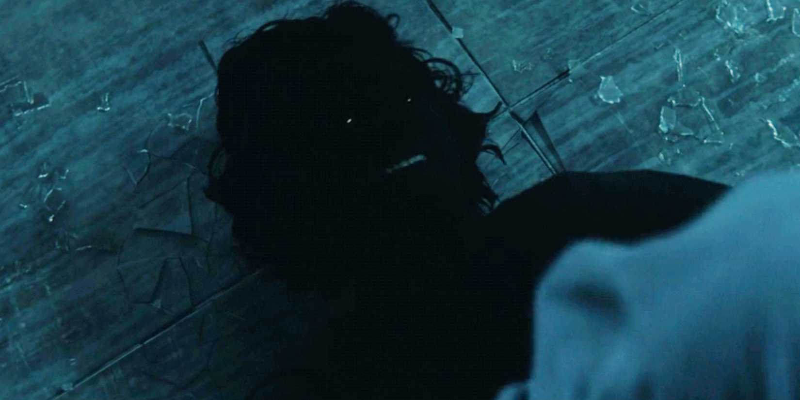 The Void laughs while lying on the ground next to shattered glass in Thunderbolts