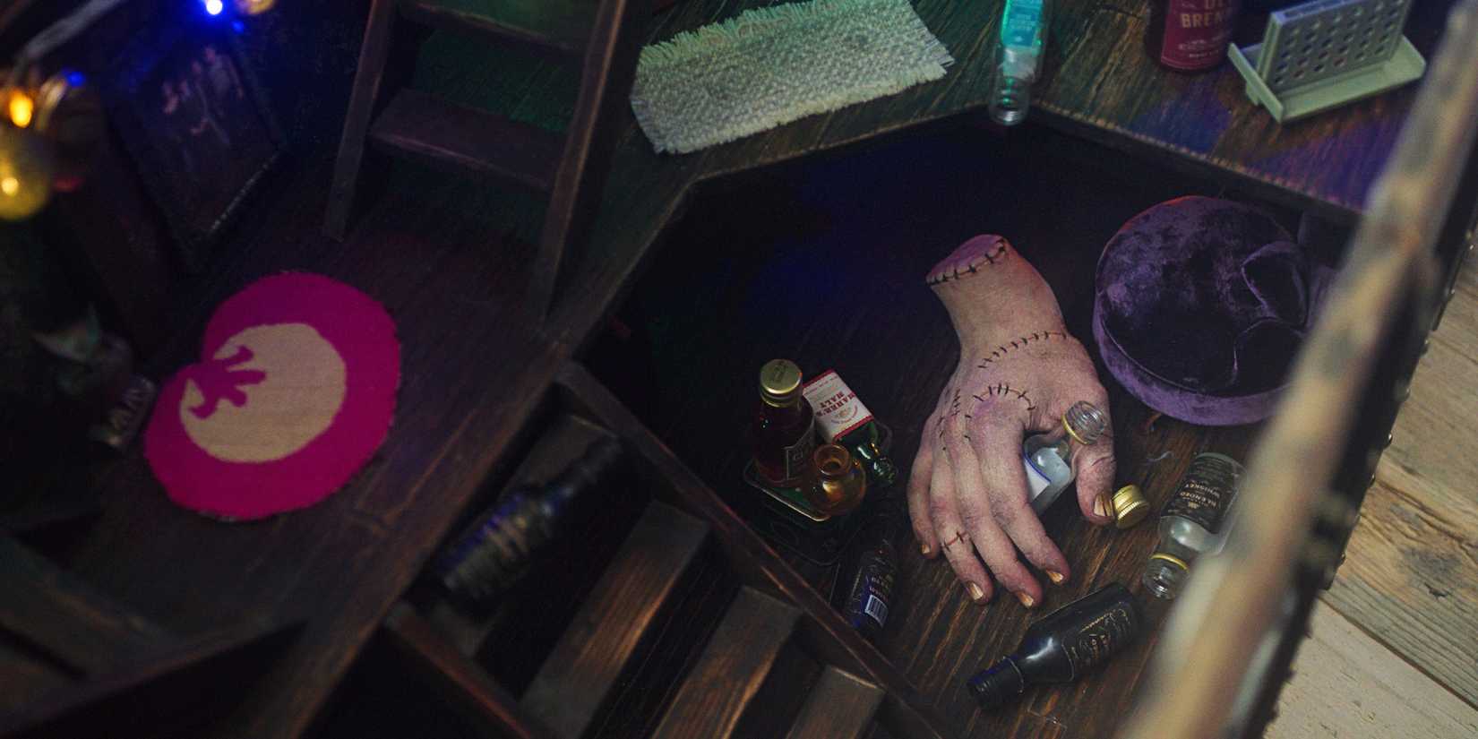 Thing surrounded by tiny alcohol bottles in Wednesday season 2