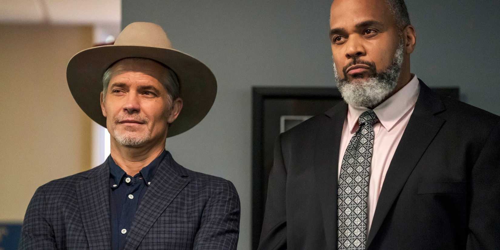Timothy Olyphant and Victor Williams stant side by side within a building, both looking satisfied, in Justified City Primeval