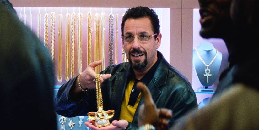 Adam Sandler holding up a necklace in Uncut Gems.