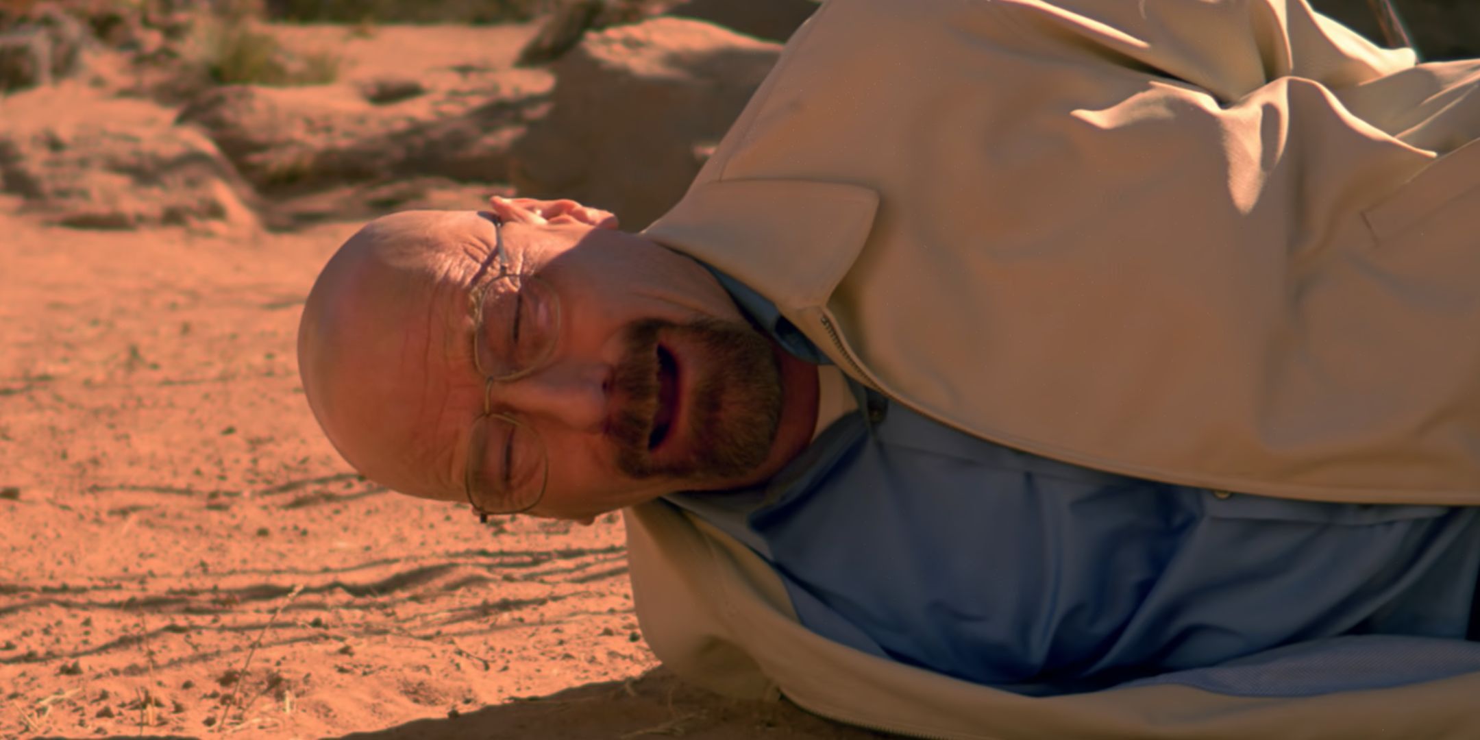 Bryan Cranston on his side and crying as Walter White in Breaking Bad
