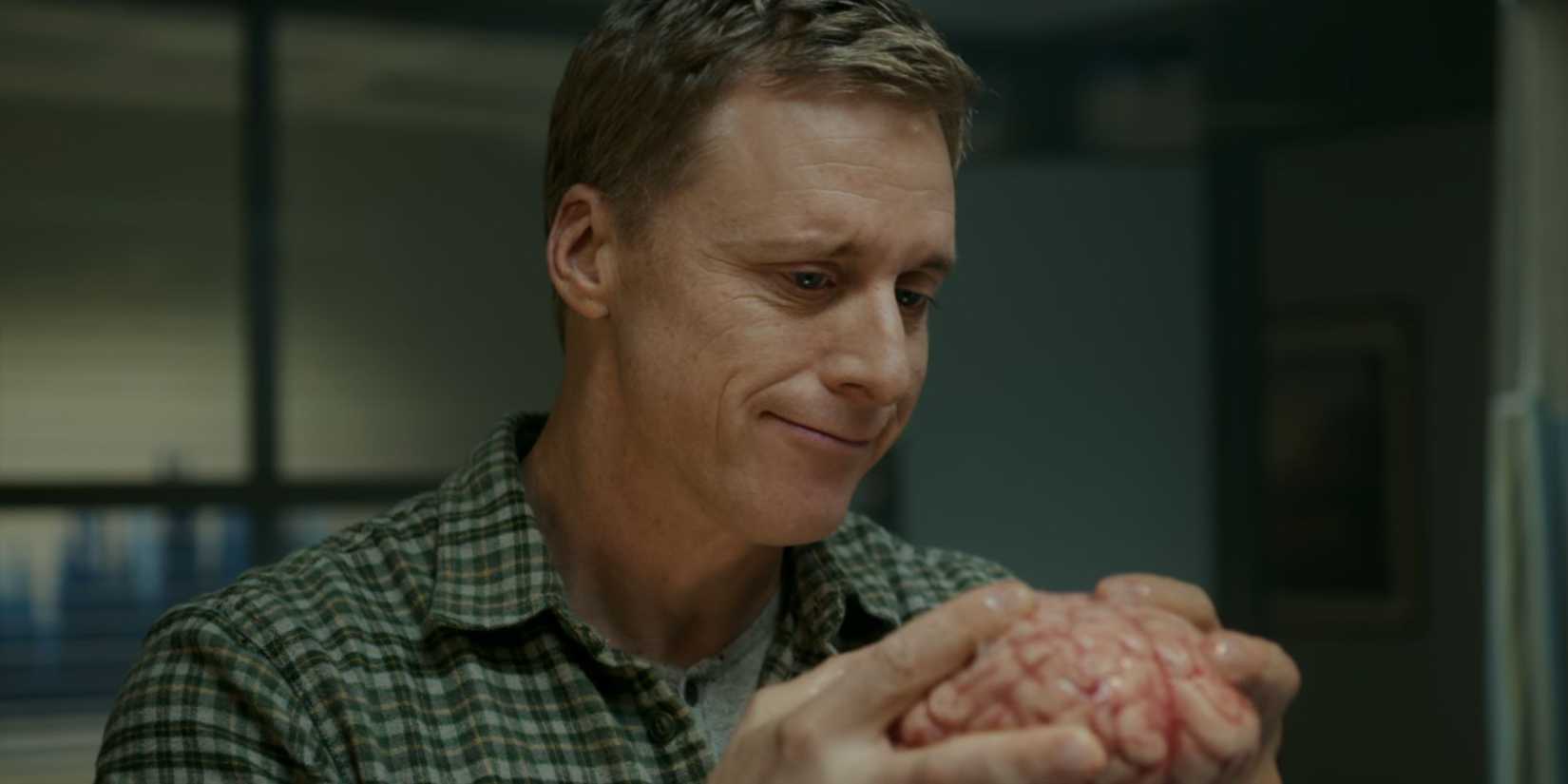 Alan Tudyk holding a brain as Harry Vanderspeigle in Resident Alien