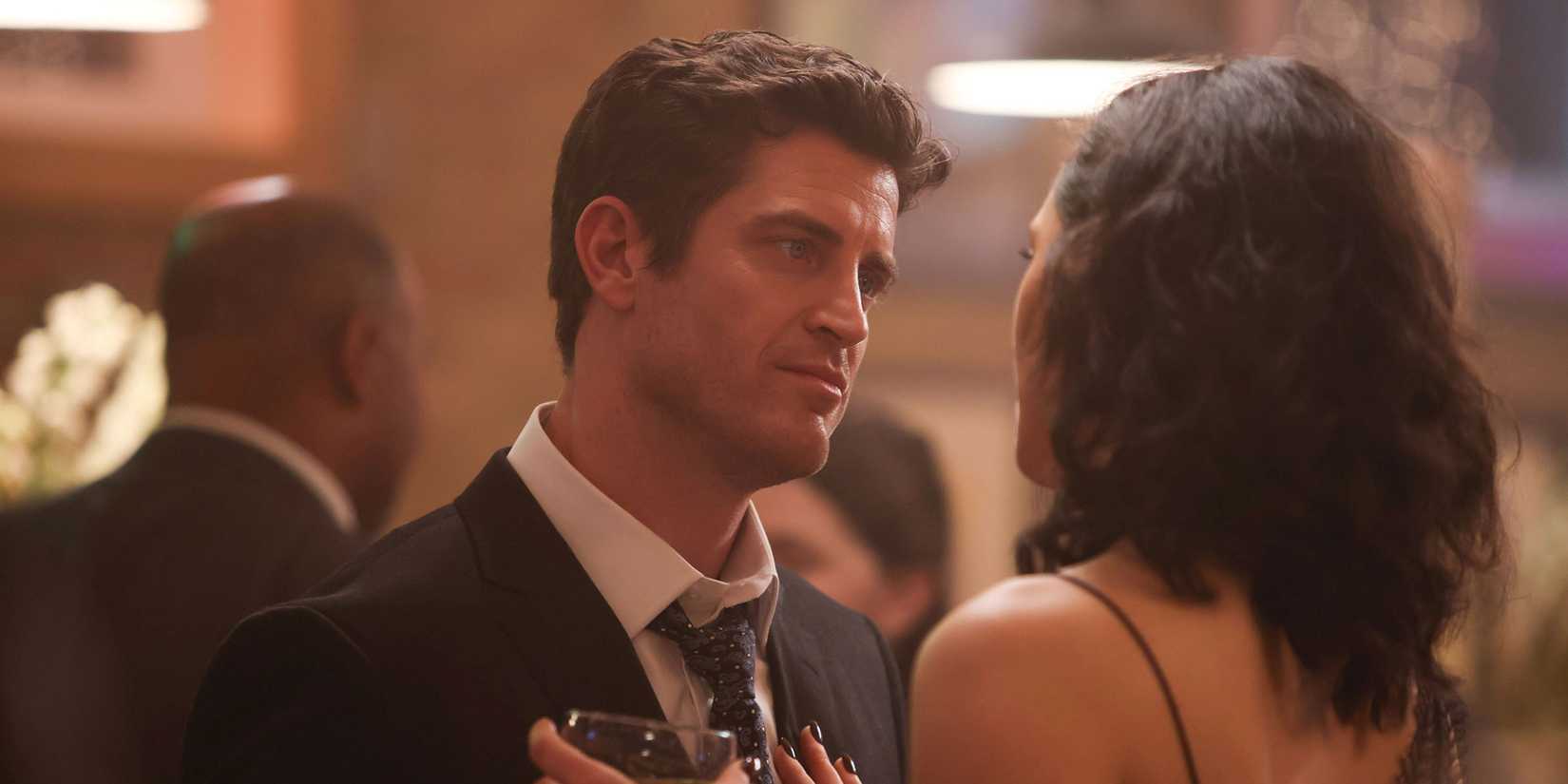 Violet looking at Carver and holding a glass in an episode of Chicago Fire