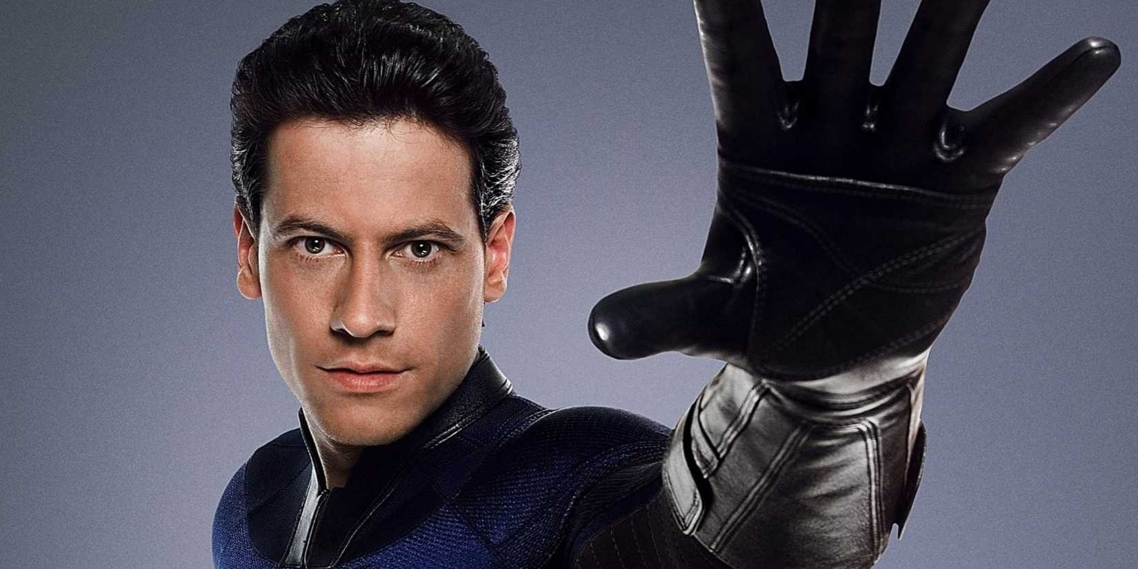 Ioan Gruffudd suited up and rising his hand as Reed Richards