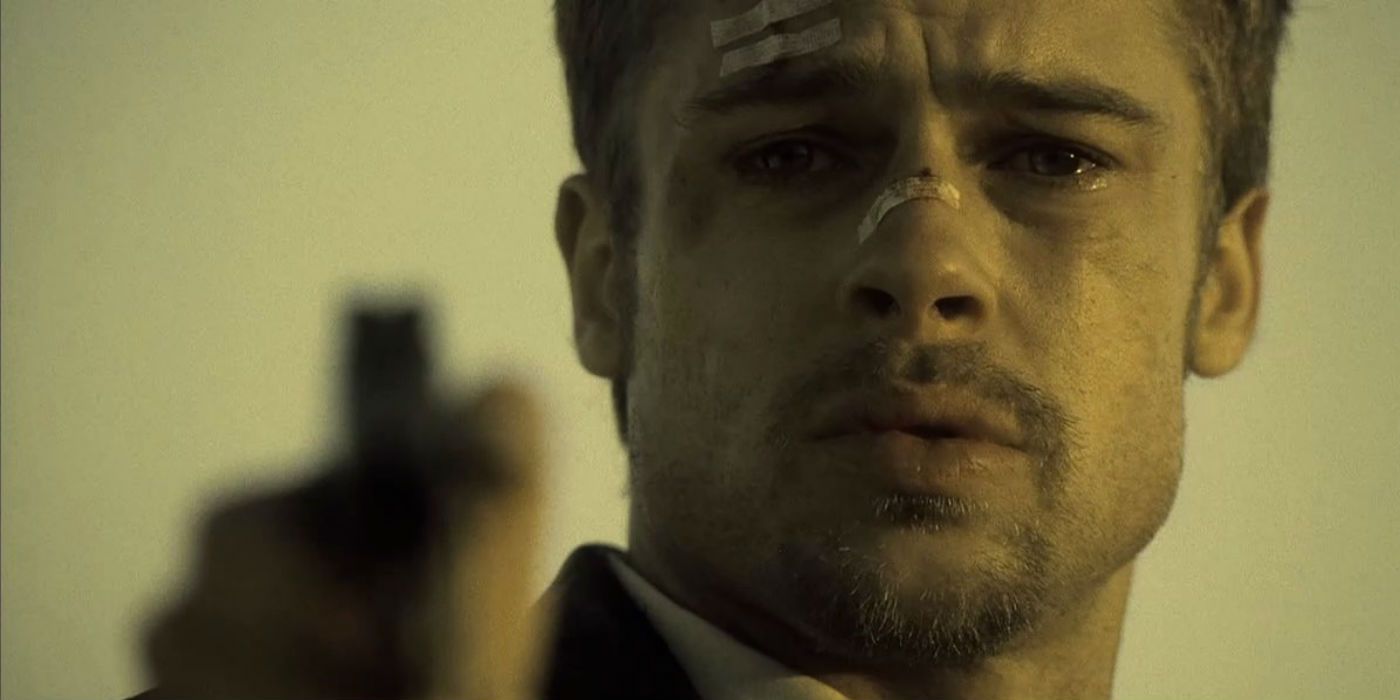 Brad Pitt aiming a gun at the camera in Se7en