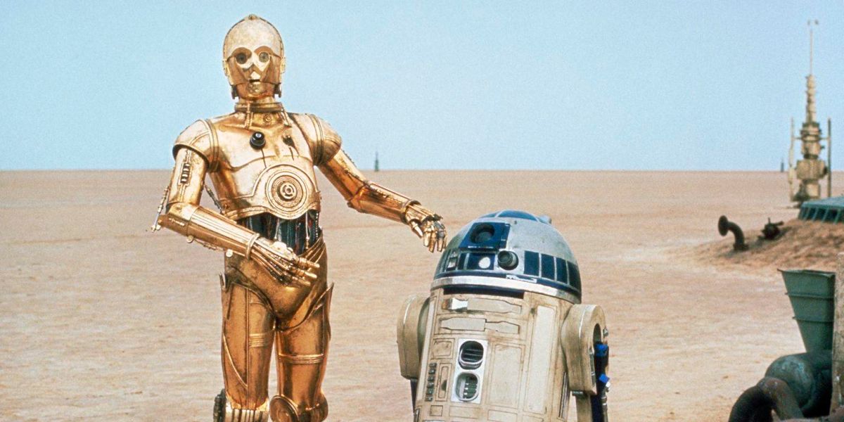 C-3PO and R2-D2 walk across the desert in Star Wars