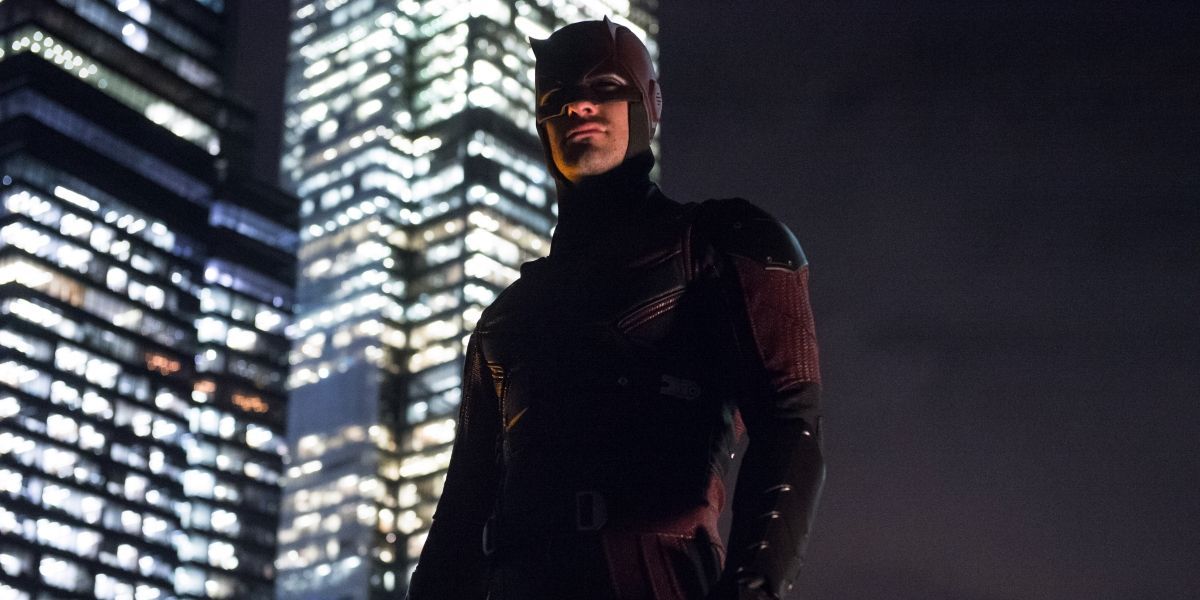 Daredevil standing atop a building at night.