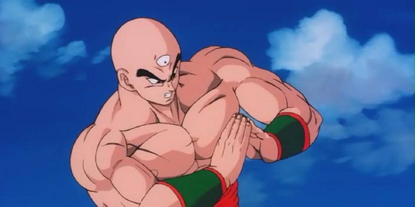 Tien Shinhan membentuk segitiga dengan tangannya untuk menyerang seseorang di luar layar di Dragon Ball Z