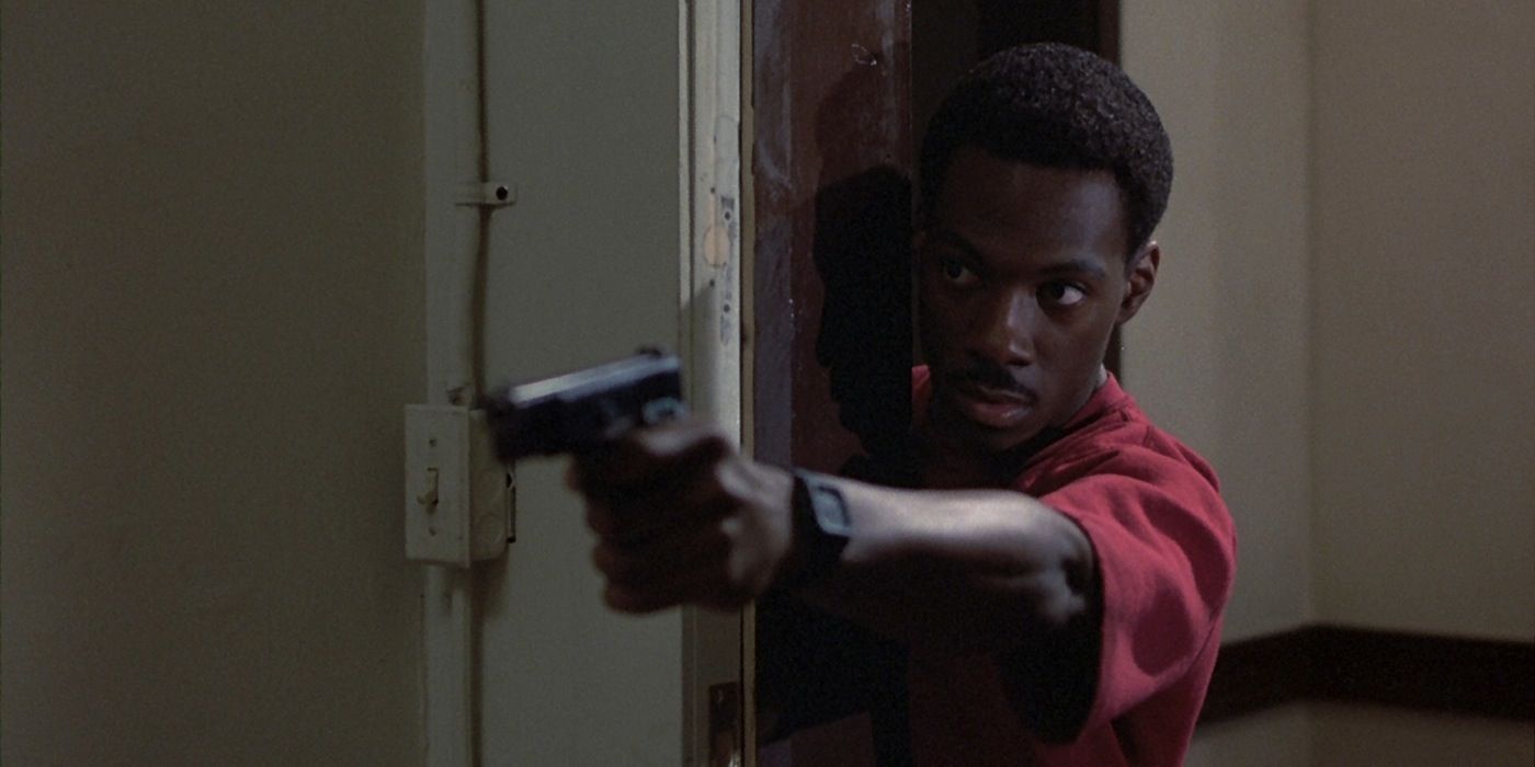 Eddie Murphy como Axel Foley apontando uma arma em Beverly Hills Cop (1984)